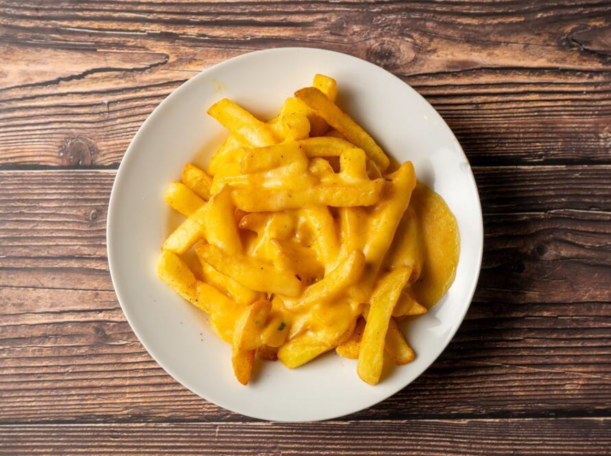 Cheesy fries on wooden table